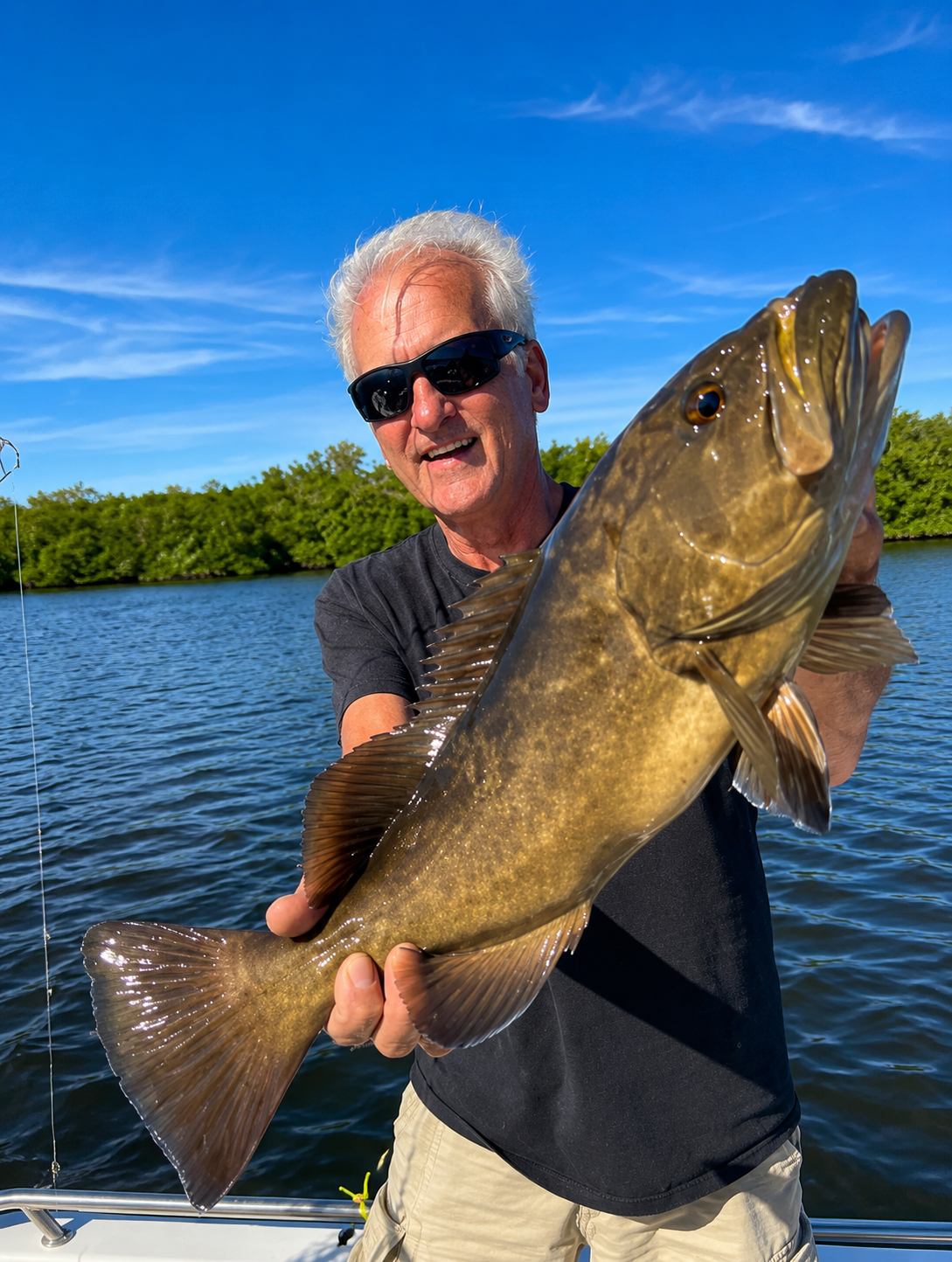 A gag grouper held up on the boat