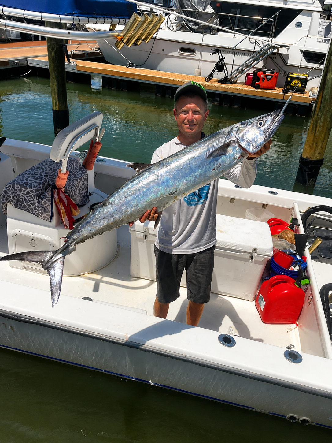 An angler with a kingfish at the dock